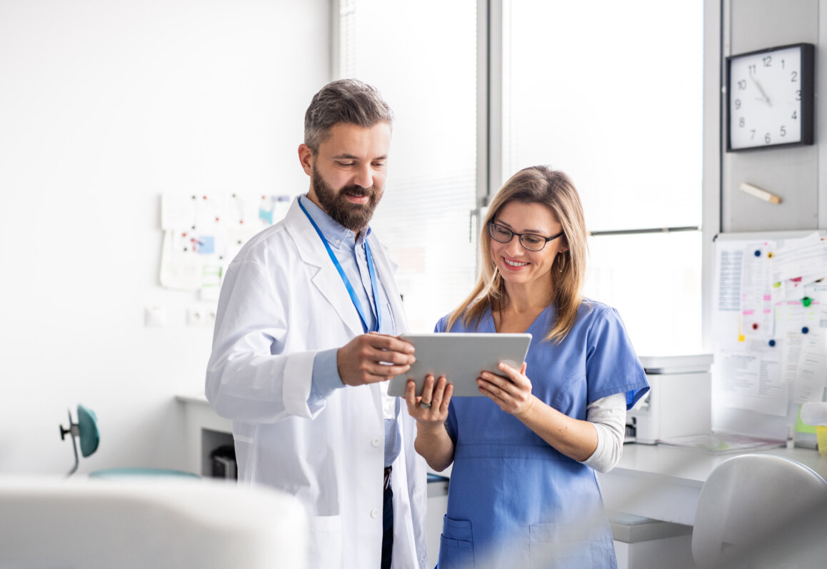 A dentist with dental assistant in modern dental surgery suite.