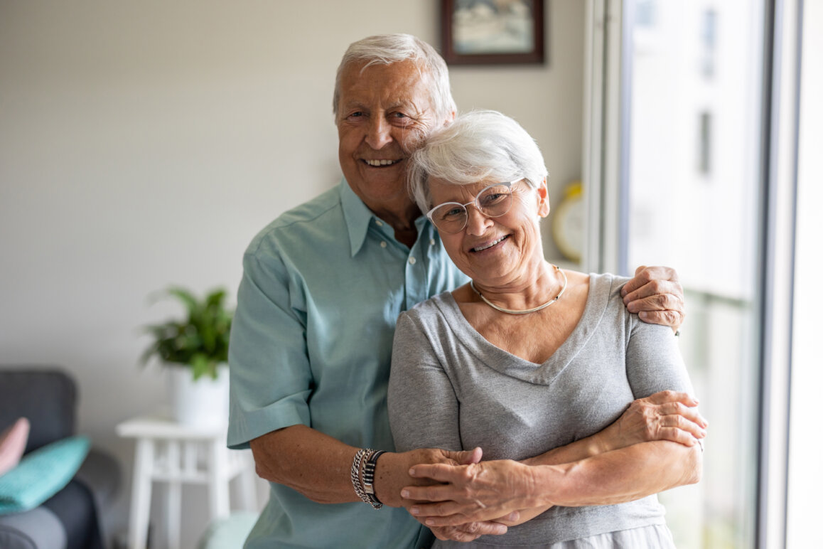 Senior couple embracing following a successful at home dental visit. - mobile